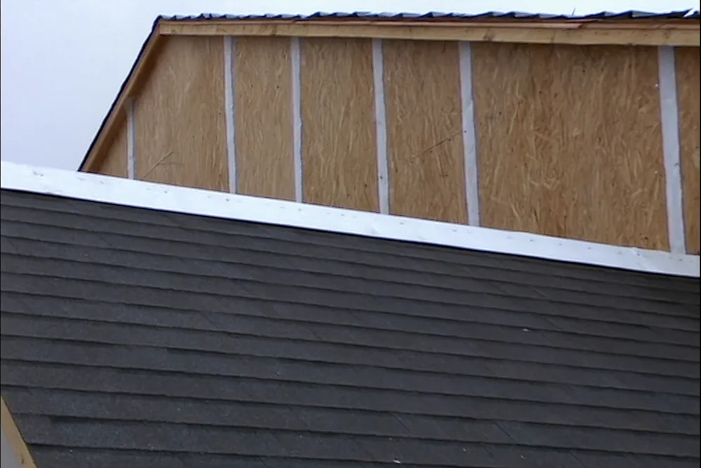 Sealing tape over the plywood sheathing seams on a roof deck during a re-roof in Oklahoma